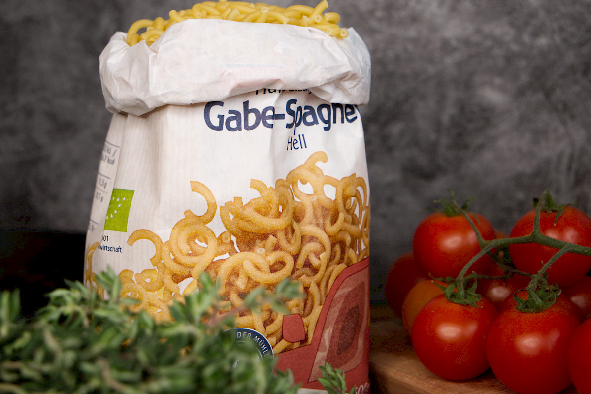 Gabelspaghetti in Papierverpackung mit Frischem Gemüse und Kräutern